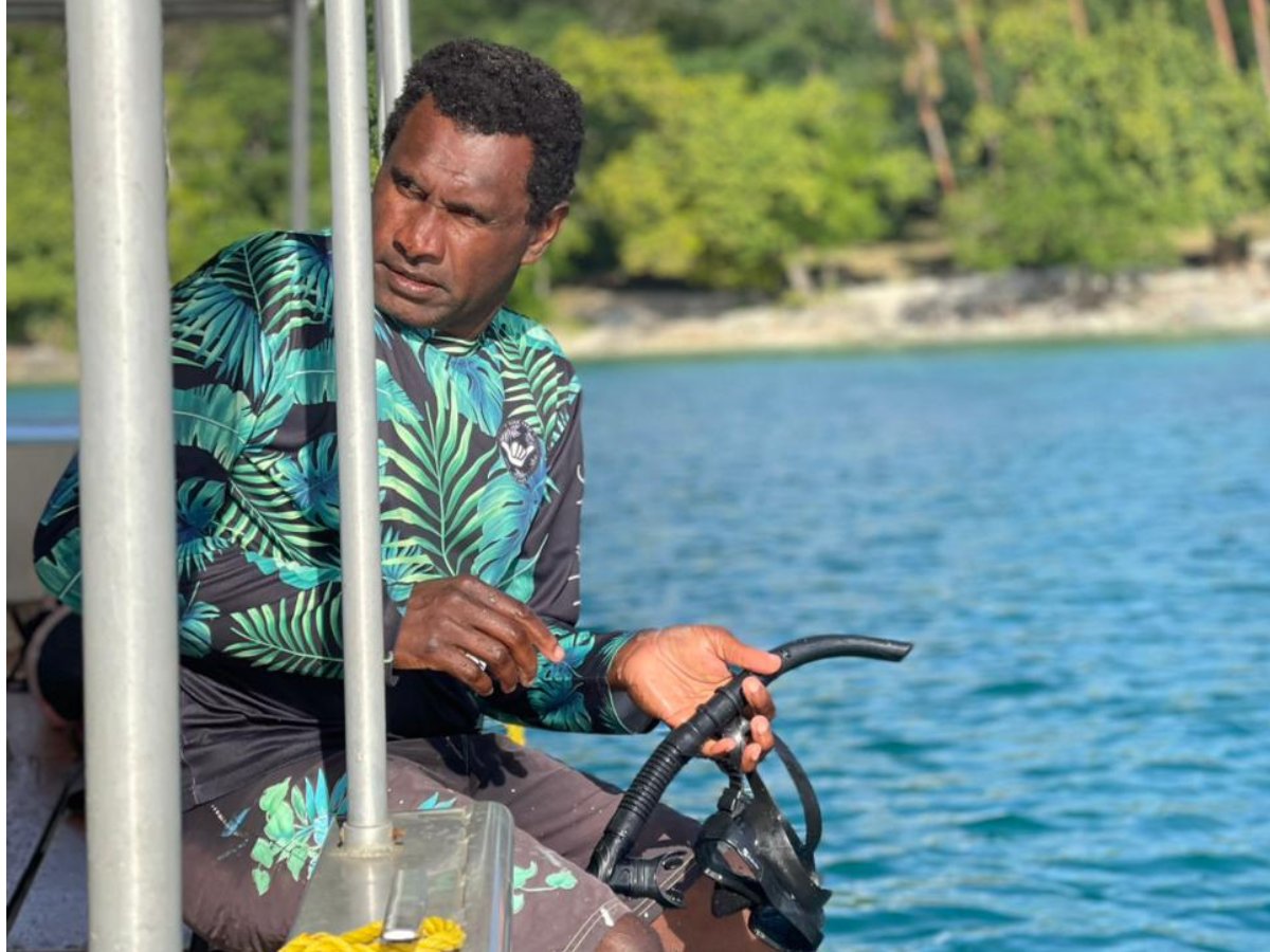 Marine guide preparing snorkel gear for a coral restoration activity
