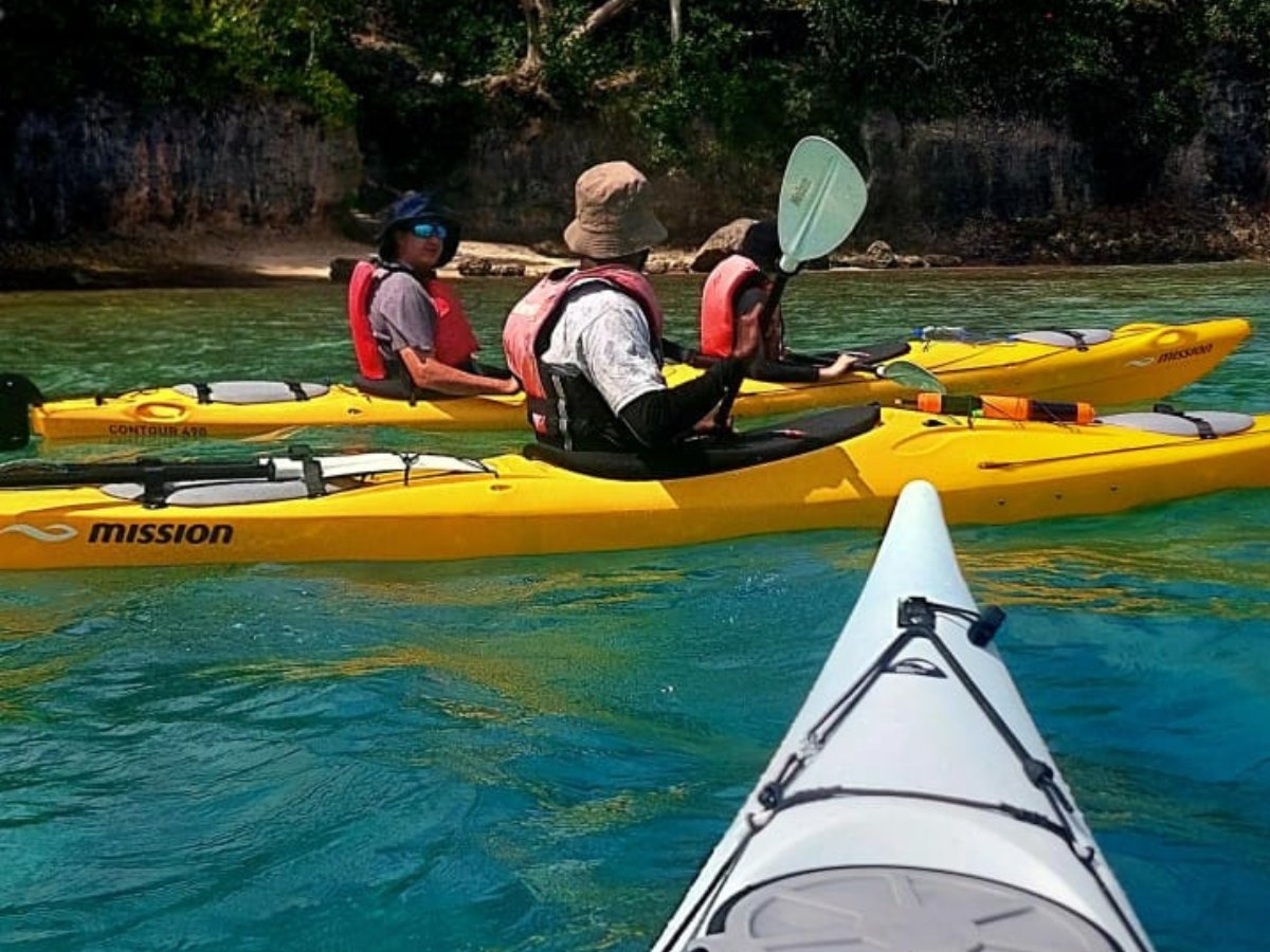 Yellow Mission kayaks paddling along the Port Vila coastline