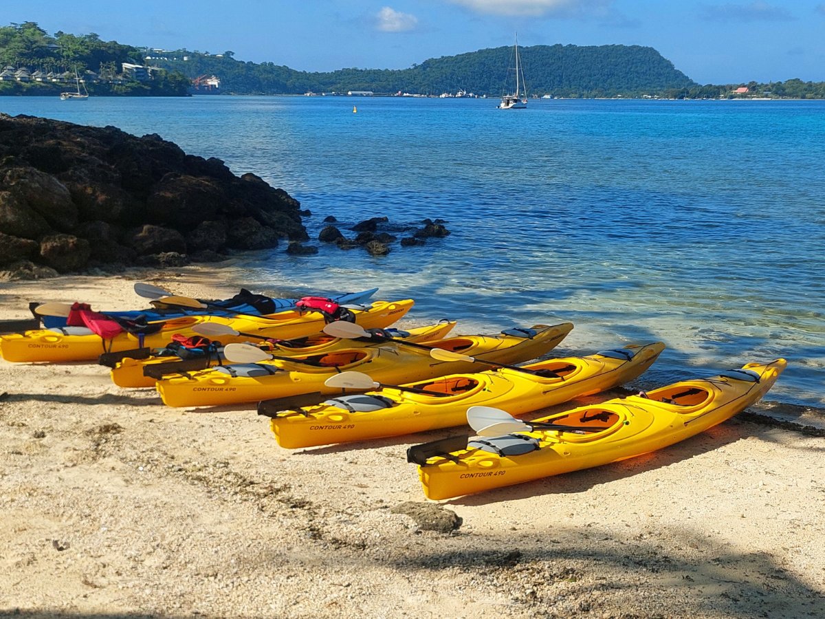 Yellow kayaks lined up on a tropical beach ready for departure
