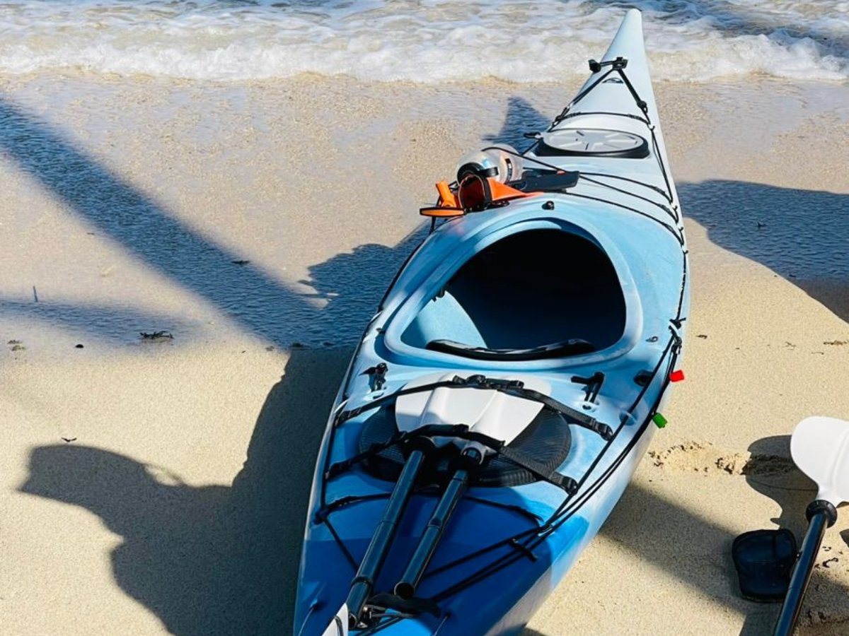 Mission kayak resting on a sandy tropical beach