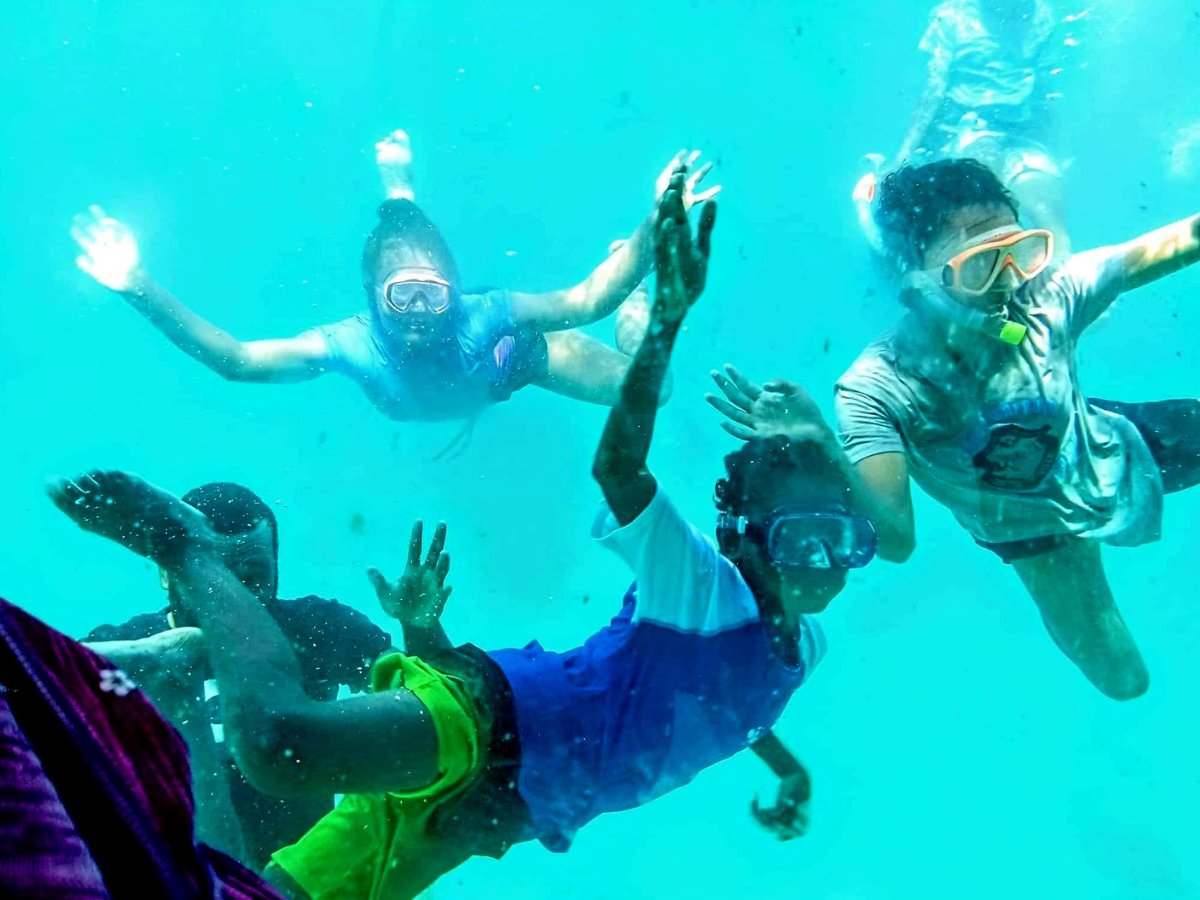 Group snorkelling in clear turquoise water at Iririki Island