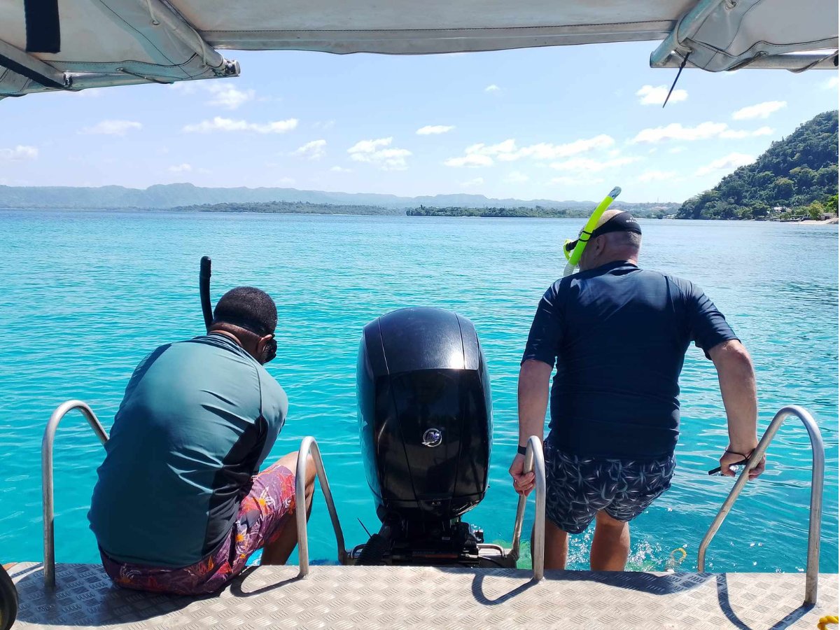 Snorkellers preparing to enter the water from the Paradise Cove tour boat