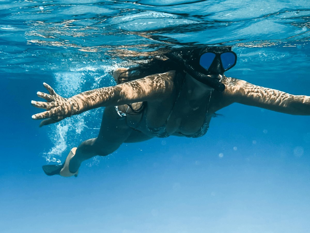 Guest snorkelling through clear turquoise water at Paradise Cove