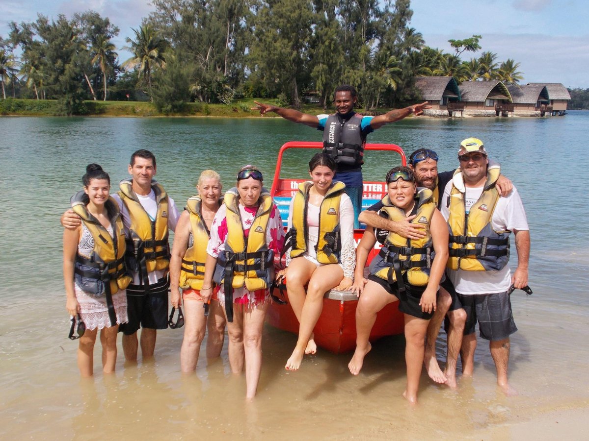 Jet boat tour group posing in shallow water after the ride